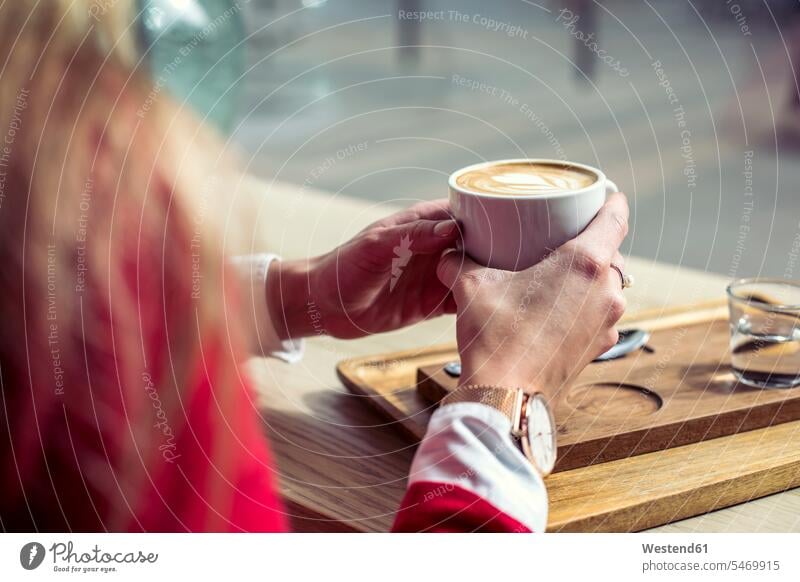 Frauenhände halten eine Tasse Kaffee, Nahaufnahme Cafe Kaffeehaus Bistro Cafes Kaffeehäuser Kaffeetasse Kaffeetassen weiblich Hand Hände Tassen Getränk Getraenk