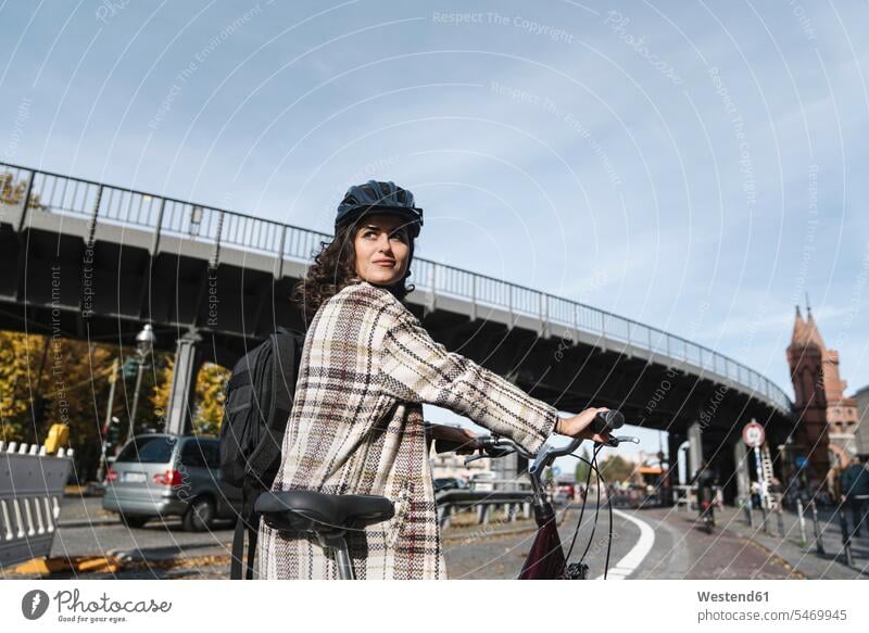 Frau mit einem Fahrrad in der Stadt, Berlin, Deutschland Rucksäcke Transport Transportwesen Raeder Räder Bike Bikes Fahrräder Rad verreisen stehend steht