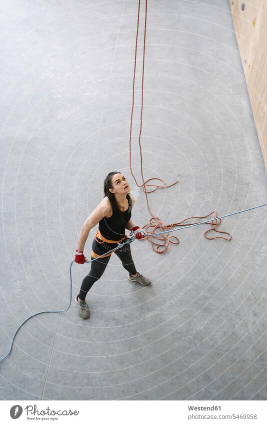 Frau mit einem Seil, das einen Partner an der Wand in einer Kletterhalle sichert (value=0) Leute Menschen People Person Personen Europäisch Kaukasier kaukasisch