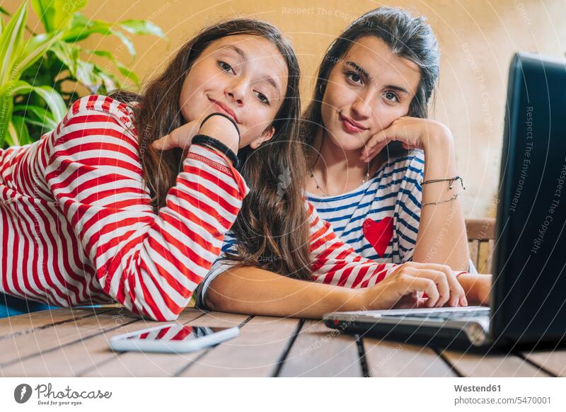 Schwestern mit Laptop auf dem Tisch zu Hause Farbaufnahme Farbe Farbfoto Farbphoto Innenaufnahme Innenaufnahmen innen drinnen 12-13 Jahre 12 bis 13 Jahre