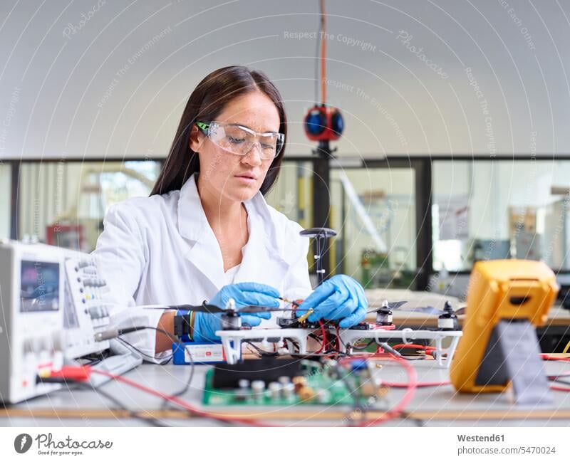 Im Forschungslabor arbeitende Technikerin, Anschlussstecker der Drohne Arbeit Drohnen Beruf Berufstätigkeit Berufe Beschäftigung Jobs Frau weiblich Frauen