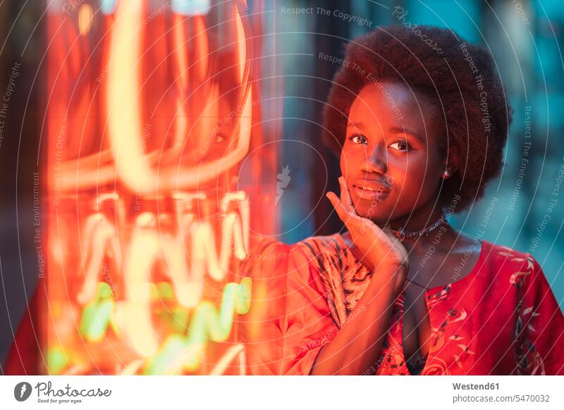 Junge Frau steht neben Neonlicht Leute Menschen People Person Personen Afrikanisch Afrikanische Abstammung dunkelhäutig Farbige Farbiger Schwarze 1 Ein