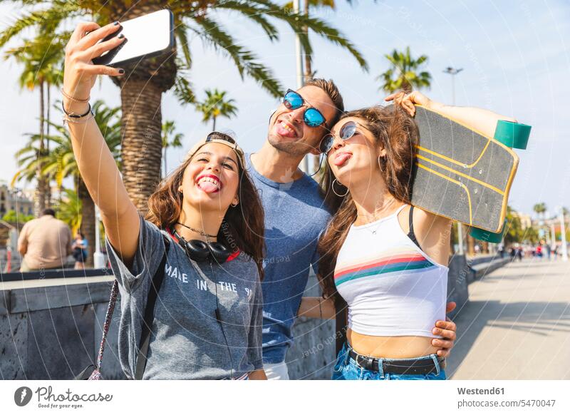 Drei verspielte Freunde mit Skateboard machen ein Selfie glücklich Glück glücklich sein glücklichsein spielerisch Stadt staedtisch städtisch Selfies