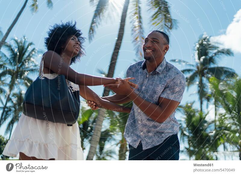 USA, Florida, Miami Beach, glückliches junges Paar an Palmen im Sommer Glück glücklich sein glücklichsein Sommerzeit sommerlich Pärchen Paare Partnerschaft