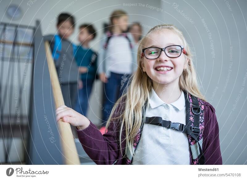 Porträt eines glücklichen Schulmädchens mit Klassenkameraden im Treppenhaus beim Verlassen der Schule verlassen Schülerin Mitschüler Glück Schulkind Bildung