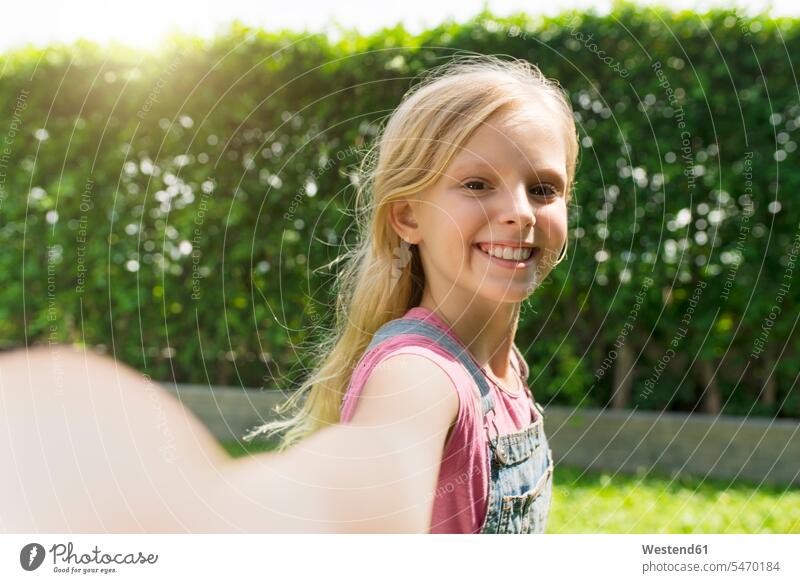 Nettes blondes Mädchen nimmt Selfie im Garten weiblich Selfies Gärten Gaerten Kind Kinder Kids Mensch Menschen Leute People Personen eine Person single 1