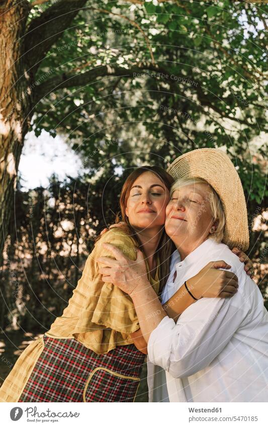 Mutter und Tochter mit geschlossenen Augen umarmen sich im Hof Farbaufnahme Farbe Farbfoto Farbphoto Spanien Freizeitbeschäftigung Muße Zeit Zeit haben