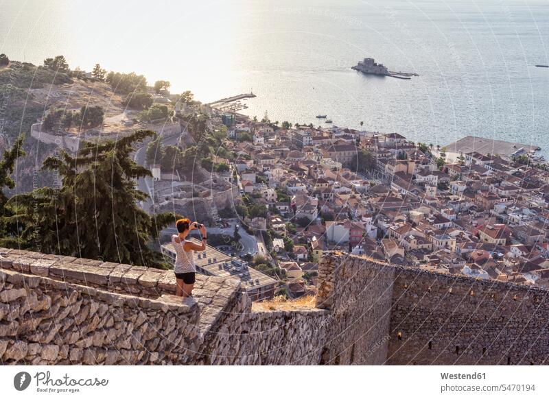 Griechenland, Peloponnes, Argolis, Nauplia, Argolischer Golf, Frau fotografiert Blick auf Burg Bourtzi Reisende Reisender Foto machen Fotos machen fotografieren
