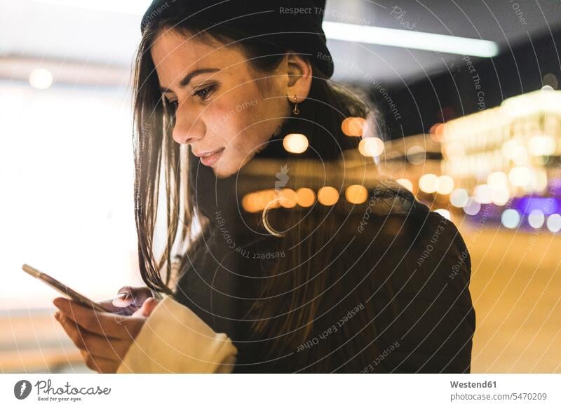 Russland, Moskau, Frau in der Stadt, die nachts auf ein Smartphone schaut Nacht weiblich Frauen staedtisch städtisch Handy Mobiltelefon Handies Handys