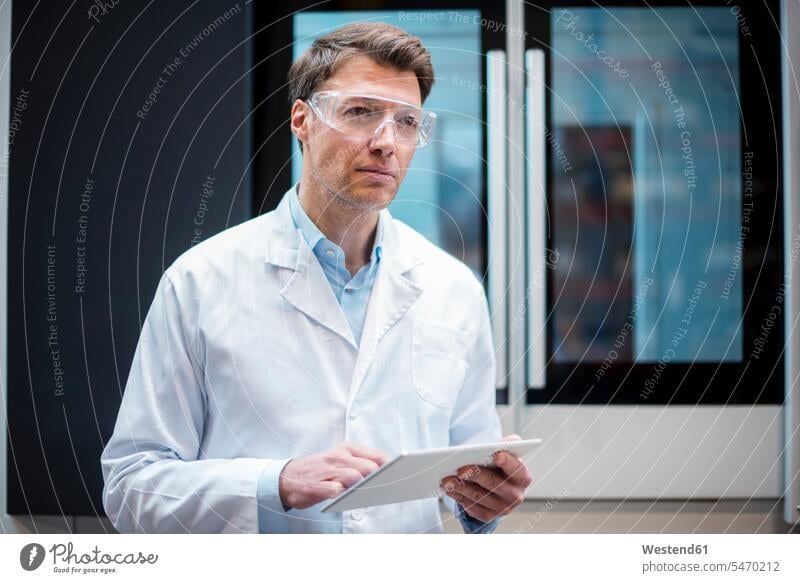Porträt eines Mannes mit Laborkittel und Schutzbrille, der die Tablette an der Maschine hält Maschinen Männer männlich Tablet Computer Tablet-PC Tablet PC iPad