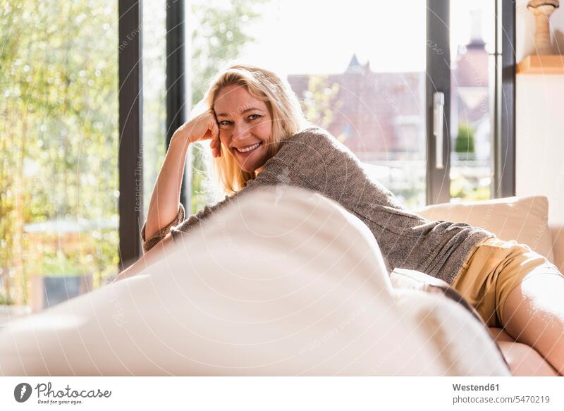 Porträt einer glücklichen reifen Frau, die sich zu Hause auf der Couch entspannt Entspannung relaxen entspannen Glück glücklich sein glücklichsein weiblich
