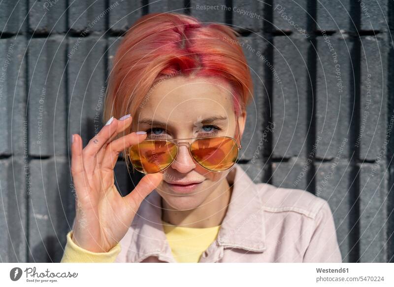 Porträt einer jungen Frau, Sonnenbrille und rosa Jeansjacke Sonnenbrillen Brille Selbstbewusstsein selbstsicher Selbstsicherheit selbstbewusst Selbstvertrauen