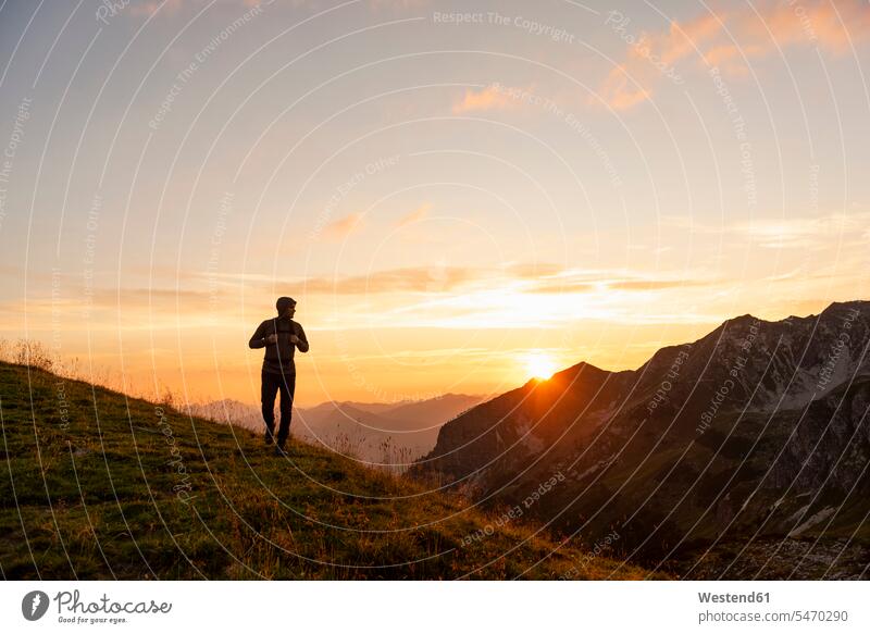 Deutschland, Bayern, Oberstdorf, Mann auf einer Wanderung in den Bergen bei Sonnenuntergang Sonnenuntergänge wandern Männer männlich Stimmung stimmungsvoll