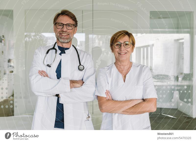 Porträt eines selbstbewussten Arztes und Assistenten in der medizinischen Praxis Job Berufe Berufstätigkeit Beschäftigung Jobs Gesundheit Gesundheitswesen