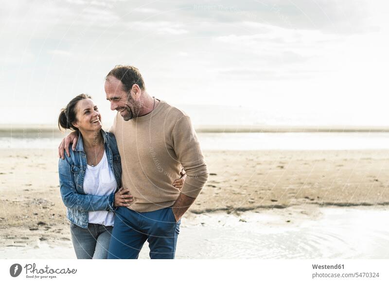 Fröhliches reifes Paar umarmt sich, während es am Wochenende gegen das Meer steht Farbaufnahme Farbe Farbfoto Farbphoto Niederlande Holland