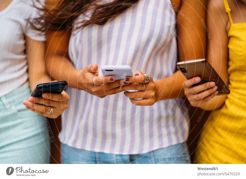 Nahaufnahme von drei jungen Frauen mit Smartphones Freunde Kameradschaft Freundin Telekommunikation telefonieren Handies Handys Mobiltelefon Mobiltelefone
