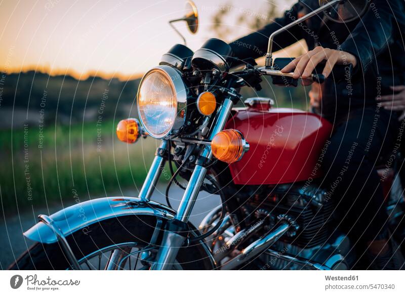 Schnappschuss eines Paares auf einem Oldtimer-Motorrad bei Sonnenuntergang Transport Transportwesen KFZ Verkehrsmittel Motorräder fahrend fahrende fahrender