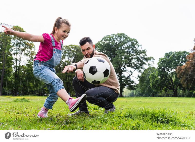 Vater spielt mit Tochter im Park Fussball spielen Töchter glücklich Glück glücklich sein glücklichsein aktiv Parkanlagen Parks Fußball Papas Väter Vati Vatis