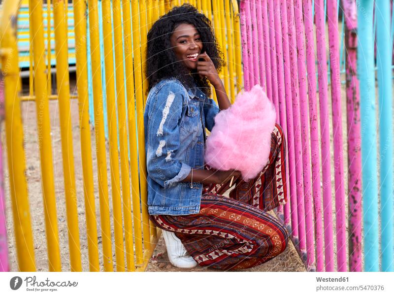 Porträt einer glücklichen jungen Frau mit rosa Zuckerwatte auf dem Jahrmarkt Leute Menschen People Person Personen Afrikanisch Afrikanische Abstammung