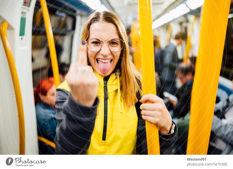 Junge Frau steht in U-Bahn-Zug und zeigt den Finger Touristen Rucksäcke Transport Transportwesen Bahnen Subway U-Bahnen Ubahn Ubahnen Underground Untergrundbahn