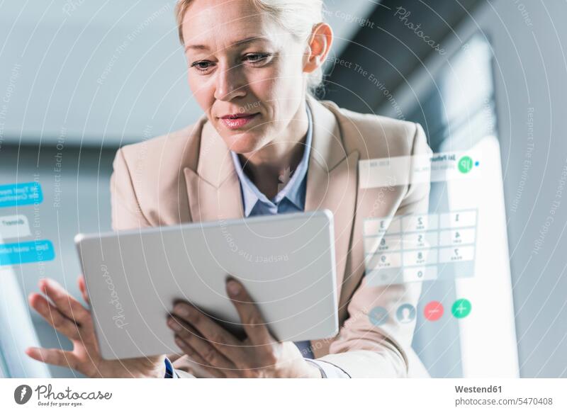 Geschäftsfrau, die im Büro sitzt und ein digitales Tablet benutzt rechnen ausrechnen arbeiten Arbeit Kontrolle kontrollieren Office Büros Geschäftsfrauen