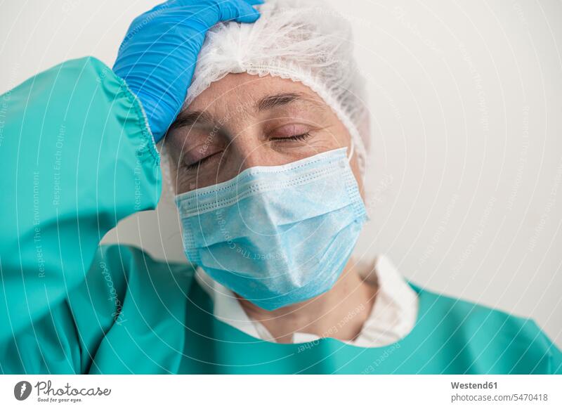 Porträt einer erschöpften Frau mit persönlicher Schutzausrüstung Job Berufe Berufstätigkeit Beschäftigung Jobs Gesundheit Gesundheitswesen medizinisch