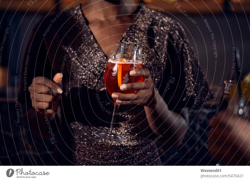 Nahaufnahme einer Frau, die in einer Bar ein Cocktailglas hält Leute Menschen People Person Personen Afrikanisch Afrikanische Abstammung dunkelhäutig Farbige