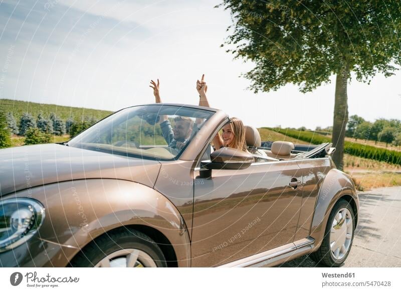 Glückliches Paar fährt im Cabrio auf einer Landstraße Auto Wagen PKWs Automobil Autos Landstraßen glücklich glücklich sein glücklichsein Pärchen Paare