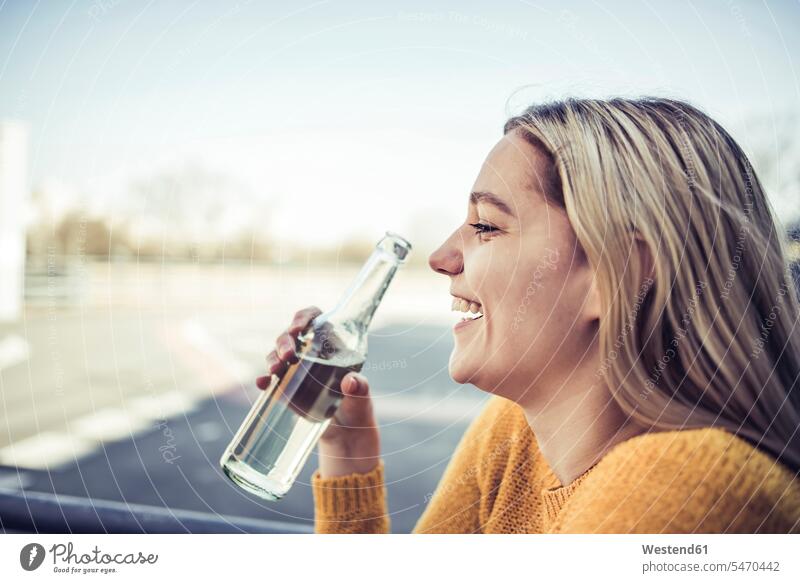 Profil einer lachenden jungen Frau mit Softdrink Deutschland gute Laune Erfrischungsgetränk Erfrischungsgetraenk Auszeit Alles hinter sich lassen abschalten