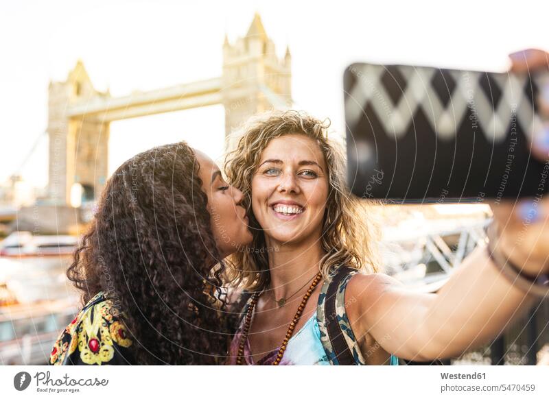 Großbritannien, London, zwei Freunde machen ein Selfie mit der Tower Bridge im Hintergrund Brücke Bruecken Brücken Freundinnen Frau weiblich Frauen glücklich