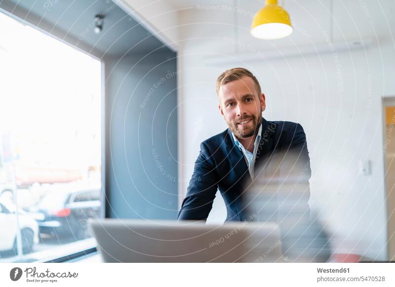 Porträt von lächelnden Geschäftsmann mit Laptop im Büro Leute Menschen People Person Personen Europäisch Kaukasier kaukasisch 1 Ein ein Mensch eine