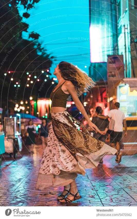 Thailand, Bangkok, junge Frau in der Stadt, die nachts auf der Straße tanzt Nacht staedtisch städtisch tanzen tanzend Strassen Straßen weiblich Frauen