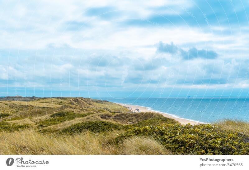 Landschaft auf der Insel Sylt mit der Nordsee und den Strandhaferhügeln Hintergrund schön blau hell wolkig Küste Küstenlinie Farbe Dunes leer Umwelt Europa