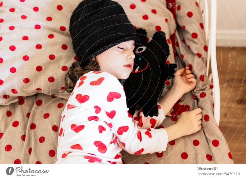 Kleines Mädchen trägt Mütze schlafen im Bett mit ihrem Stofftier Europäer Kaukasier Europäisch kaukasisch Augen geschlossen geschlossene Augen unkonventionell
