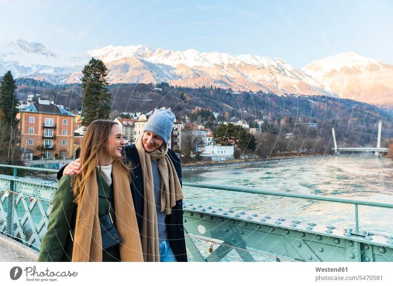 Österreich, Innsbruck, glückliches junges Paar beim gemeinsamen Winterspaziergang spazierengehen Spaziergang machen spazieren gehen Gemeinsam Zusammen