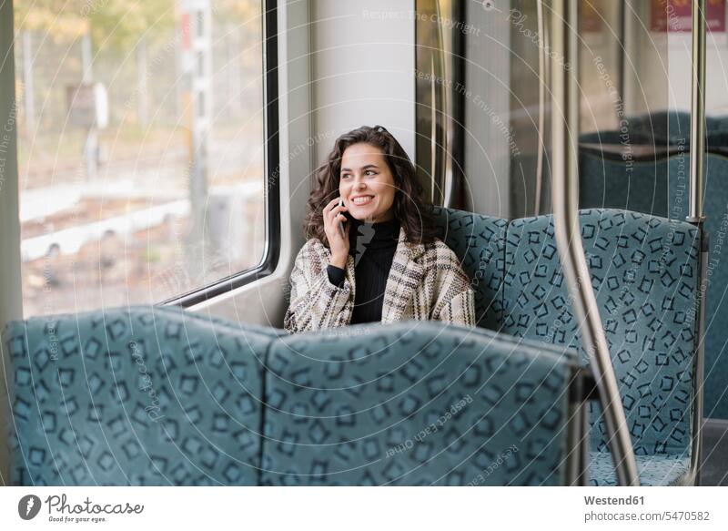 Lächelnde junge Frau am Telefon in der U-Bahn Fensterscheiben Transport Transportwesen Bahnen Subway U-Bahnen Ubahn Ubahnen Underground Untergrundbahn
