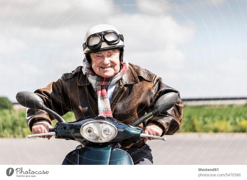 Aktiver älterer Mann, der mit seinem Motorroller zu schnell fährt Aktive Senioren Seniorinnen Aktiv im Alter Rüstige Rentner Schnelligkeit geschwind