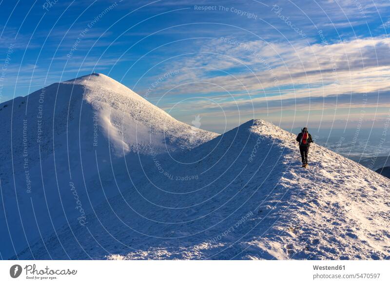 Italien, Provinz Pesaro und Urbino, Männlicher Wanderer beim Aufstieg auf den schneebedeckten Gipfel des Monte Acuto Außenaufnahme außen draußen im Freien Tag