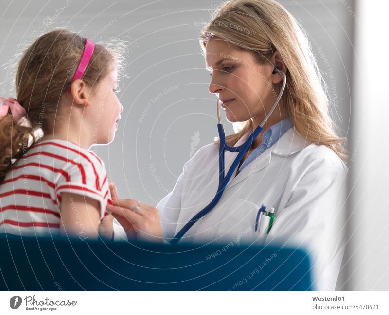 Ärztin, die in einer Klinik das Herz eines jungen Mädchens mit einem Stethoskop abhört Leute Menschen People Person Personen Europäisch Kaukasier kaukasisch 2