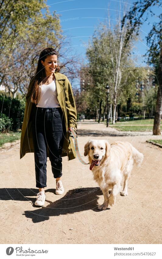 Glückliche Frau beim Gassi gehen im Stadtpark mit ihrem Labrador Retriever Barcelona Gassigehen Hundeleine Leine Tiermotive Tierthemen Menschen zufällige
