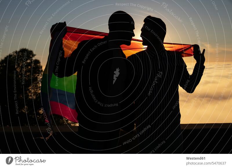 Silhouette von Homosexuell Paar mit Homosexuell Stolz Flagge im Gegenlicht Leute Menschen People Person Personen Europäisch Kaukasier kaukasisch 2 2 Menschen