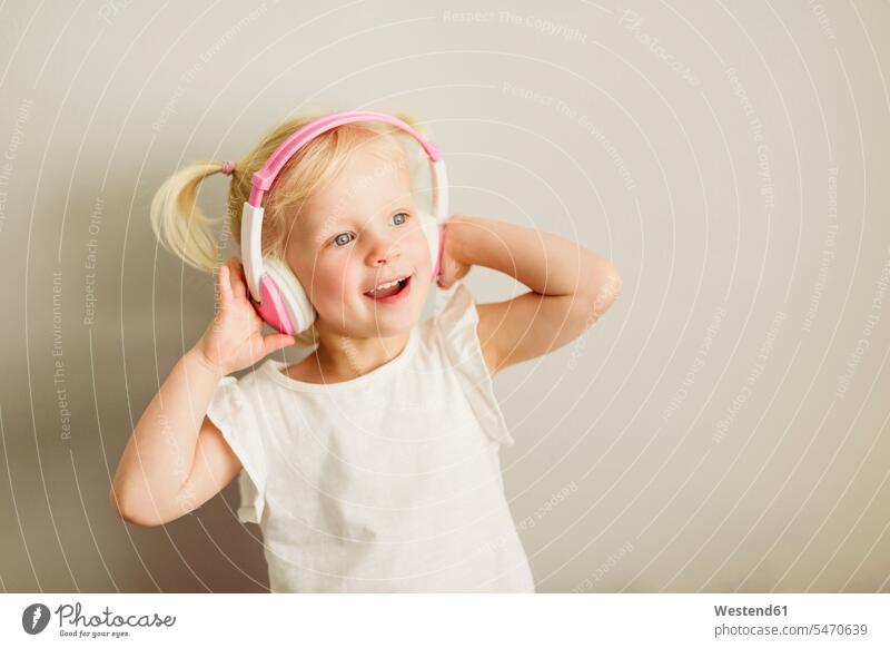 Porträt eines kleinen Mädchens, das mit Kopfhörern Musik hört und tanzt Kopfhoerer hören hoeren weiblich Portrait Porträts Portraits tanzen tanzend Kind Kinder