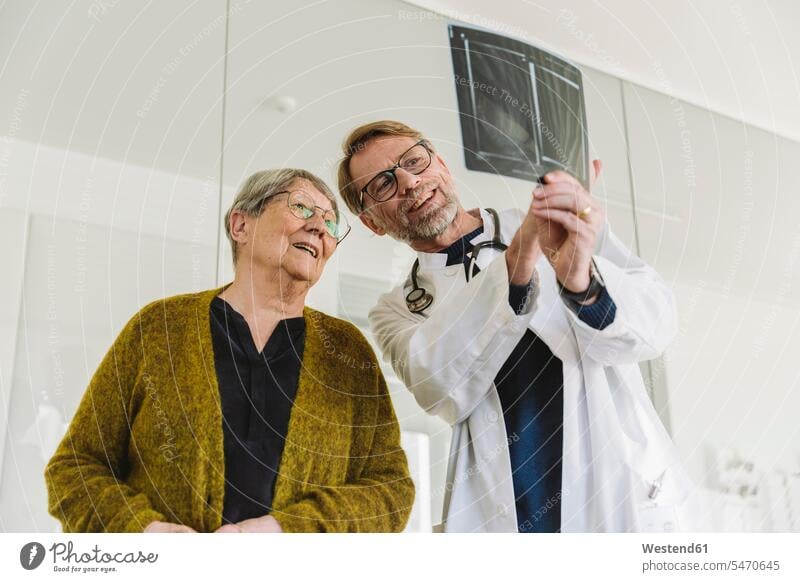 Arzt bespricht Röntgenbild einer gebrochenen Hand mit älterem Patienten Gesundheit Gesundheitswesen medizinisch Erkrankung Erkrankungen Krankheiten Kranke