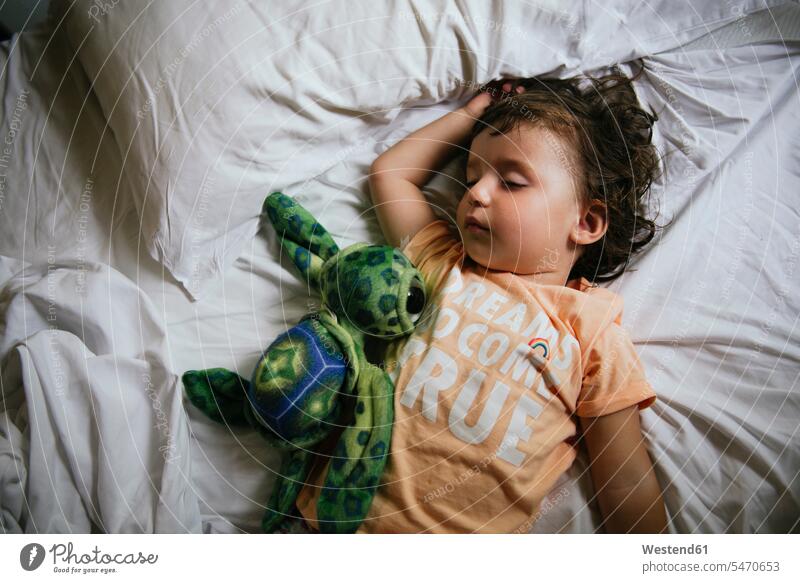 Baby-Mädchen schlafend auf Bett mit T-Shirt Nachricht 'Träume wahr werden' früh Pyjama Schlafanzuege Schlafanzug Schlafanzüge Portrait Porträts Portraits Betten