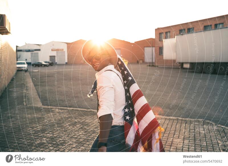 Lachender junger Mann mit amerikanischer Flagge im Gegenlicht Fahnen Flaggen lachen amerikanische Flagge Männer männlich Gegenlichtaufnahme Gegenlichtaufnahmen