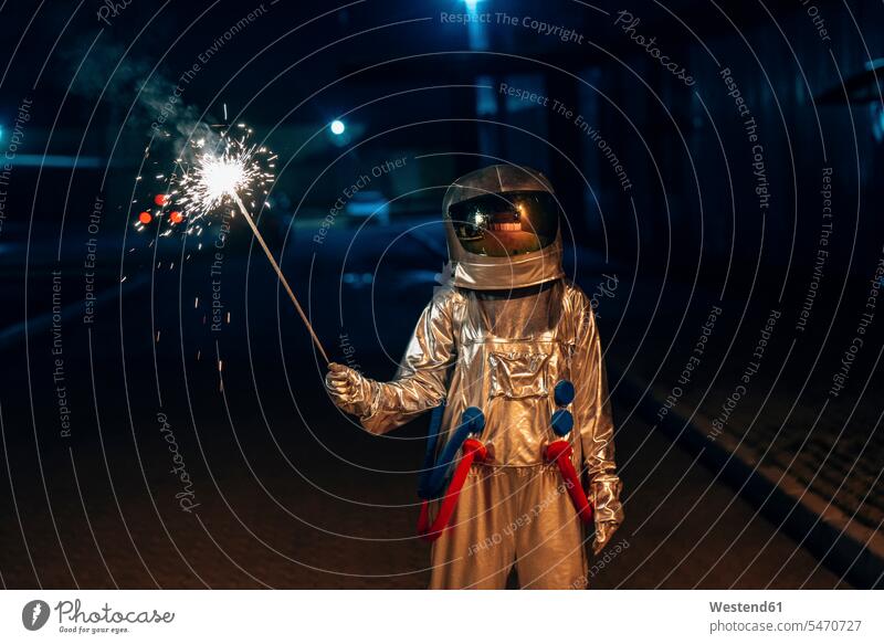 Raumfahrer steht nachts im Freien und hält Wunderkerze Wunderkerzen Nacht Weltraumfahrer Astronaut Astronauten halten stehen stehend Raumfahrt Sehnsucht