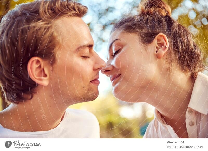 Junges verliebtes Paar küsst sich in einem Park küssen Küsse Kuss Parkanlagen Parks Pärchen Paare Partnerschaft Mensch Menschen Leute People Personen fühlen