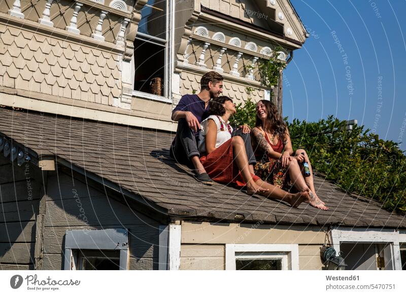 Glückliche Freunde sitzen auf dem Dach sitzend sitzt Freundschaft Kameradschaft Originalität originell authentisch Nonkonformität alternativer Lebensstil
