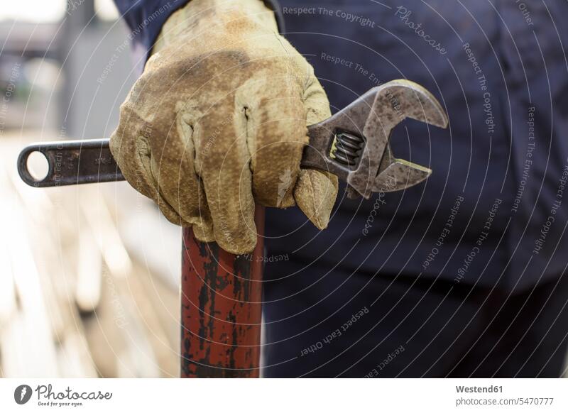 Bauarbeiter hält einen Schraubenschlüssel Arbeiter Beruf Berufstätigkeit Berufe Beschäftigung Jobs Schutz geschützt schützen Rohr Rohre Handschuh Handschuhe