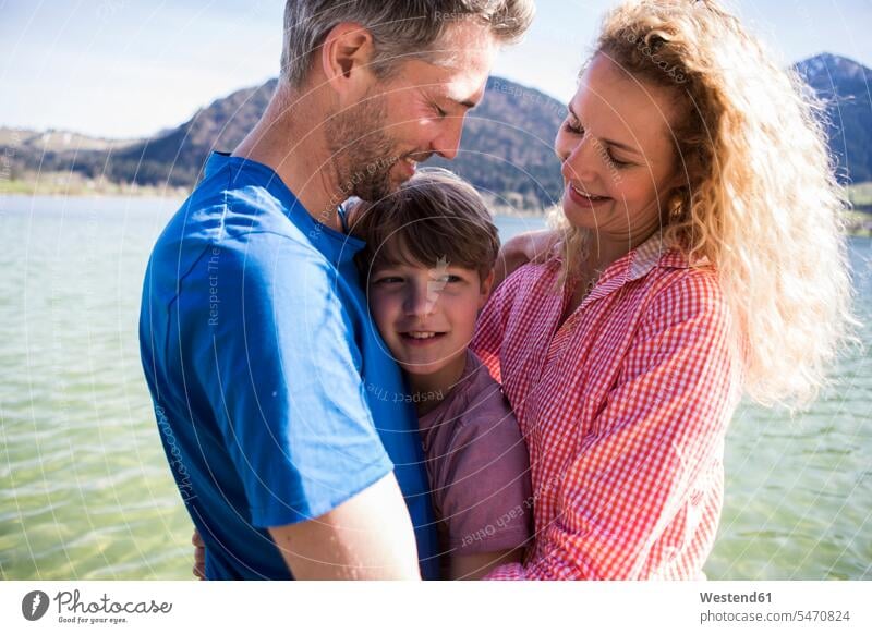 Österreich, Tirol, Walchsee, glücklicher Elternteil mit Sohn eng beieinander am See Söhne Mutter Mami Mutti Mütter Mama Familie Familien Glück glücklich sein